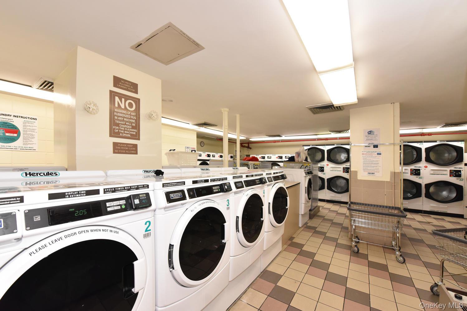 175-20 Wexford Terrace, Unit 16L Queens, NY 11432 - Photo 22 of 26 a view of washer and dryer with kitchen in the background
