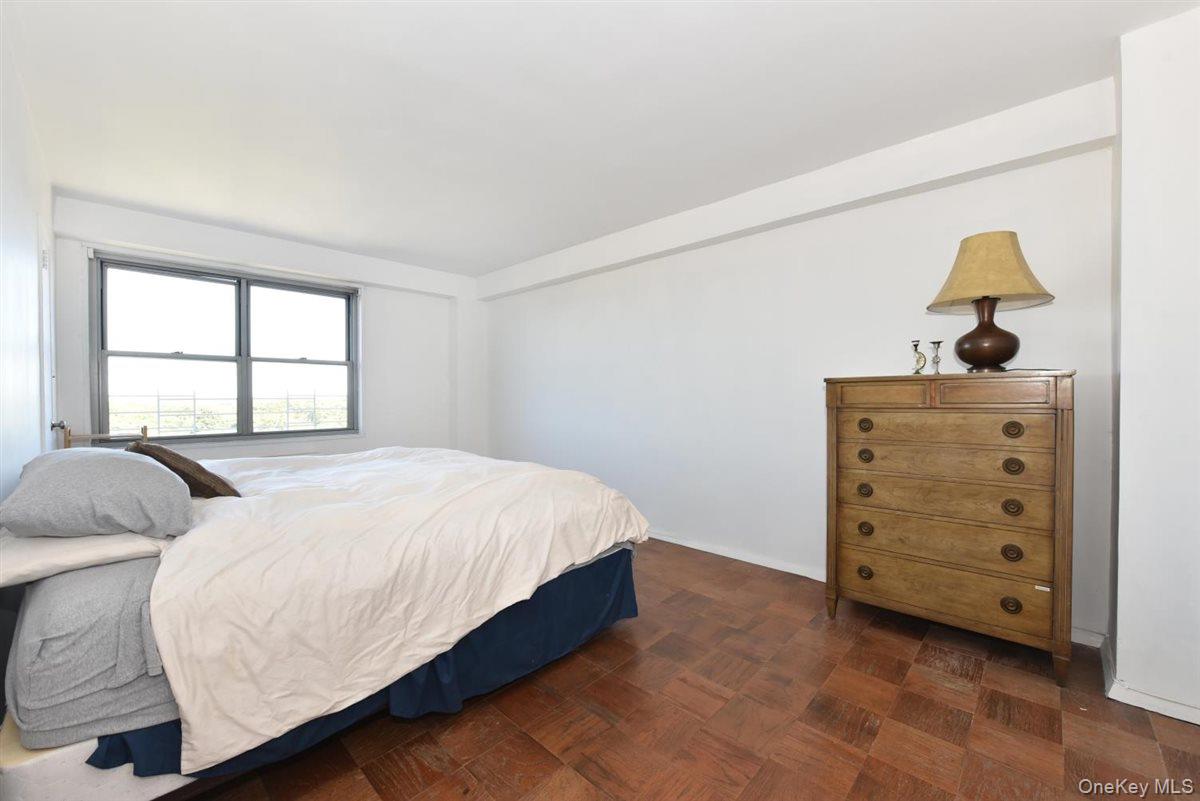 175-20 Wexford Terrace, Unit 16L Queens, NY 11432 - Photo 7 of 26 a bedroom with a bed and window