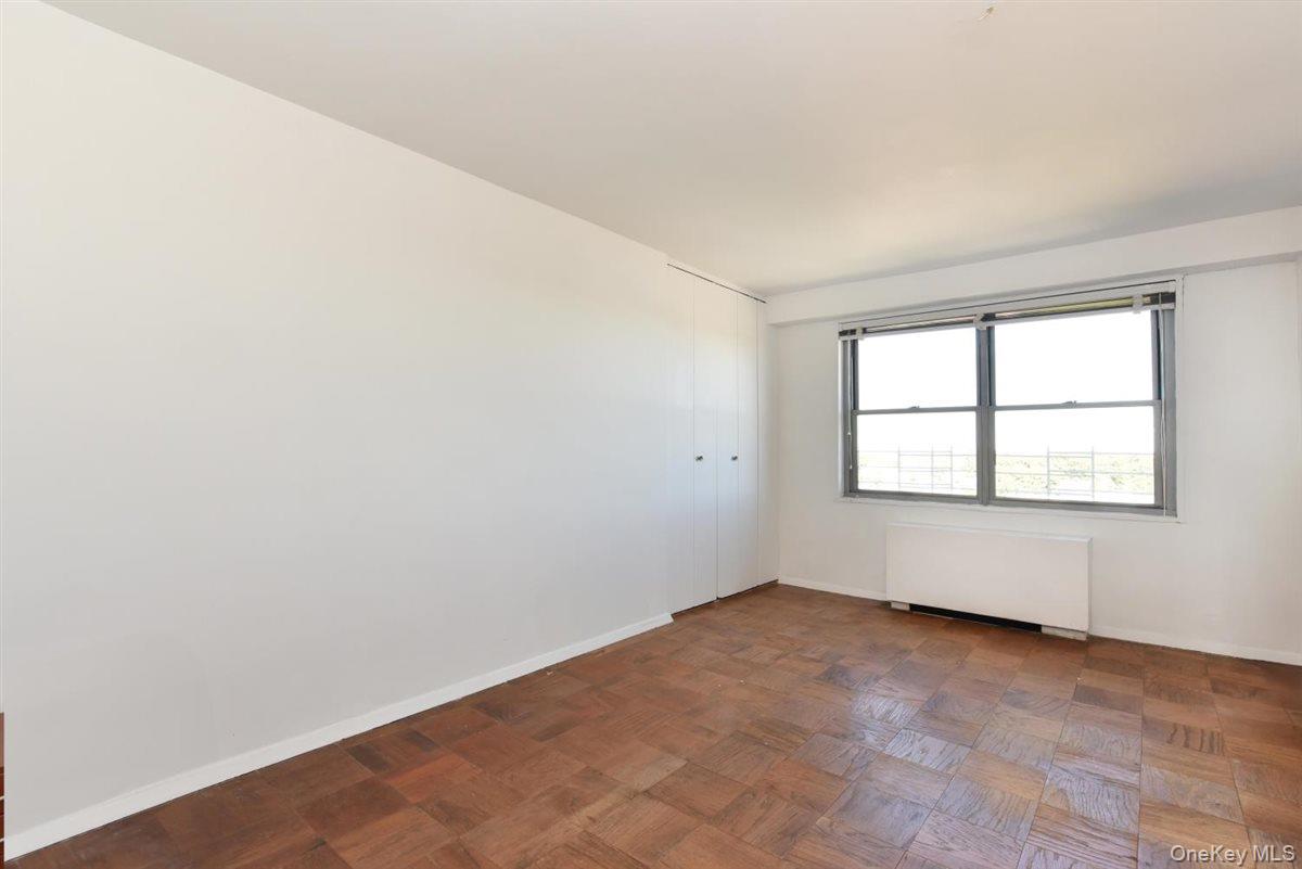 175-20 Wexford Terrace, Unit 16L Queens, NY 11432 - Photo 10 of 26 an empty room with a window