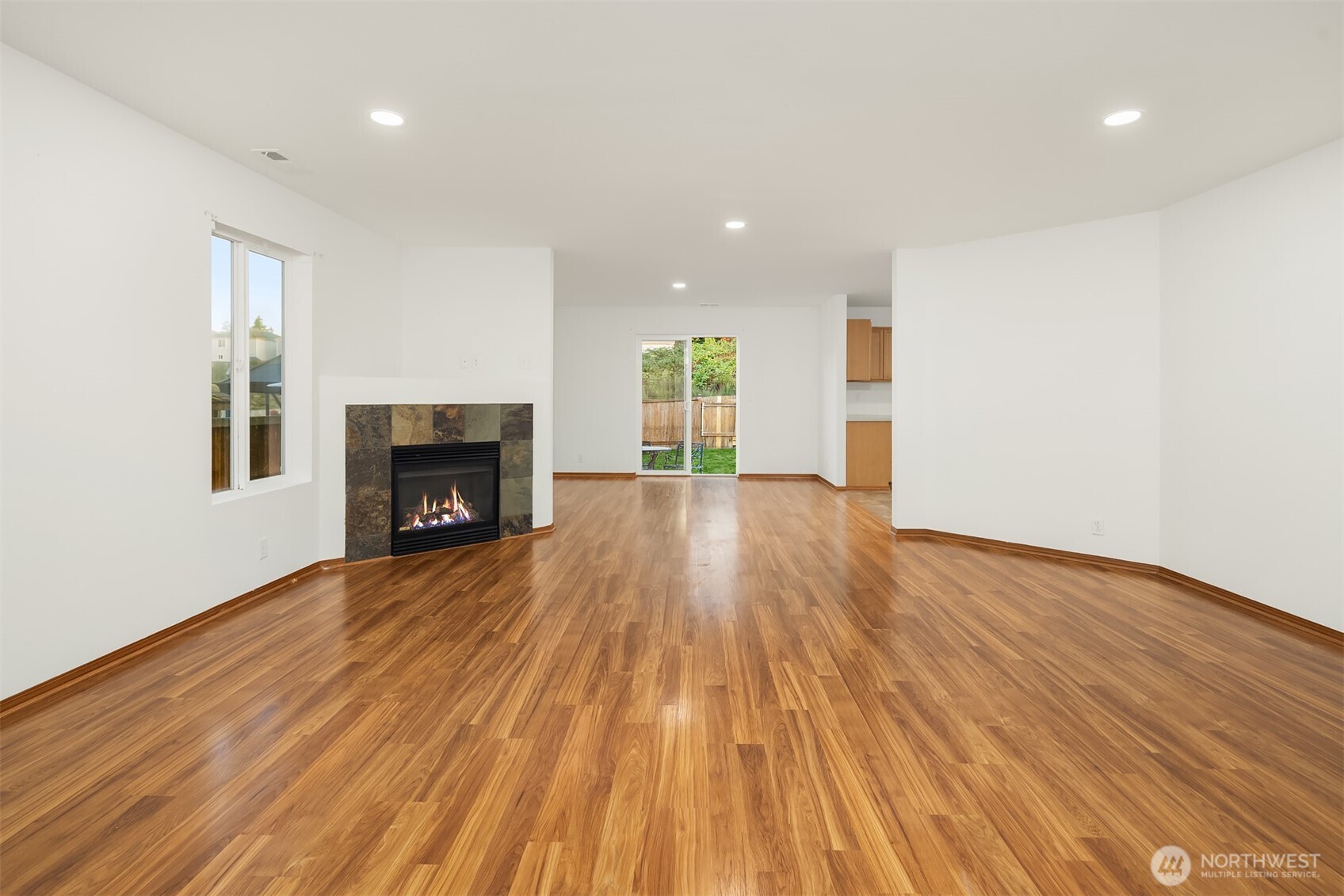 21353 Southeast 289th Way Kent, WA 98042 - Photo 15 of 40 an empty room with wooden floor fireplace and windows