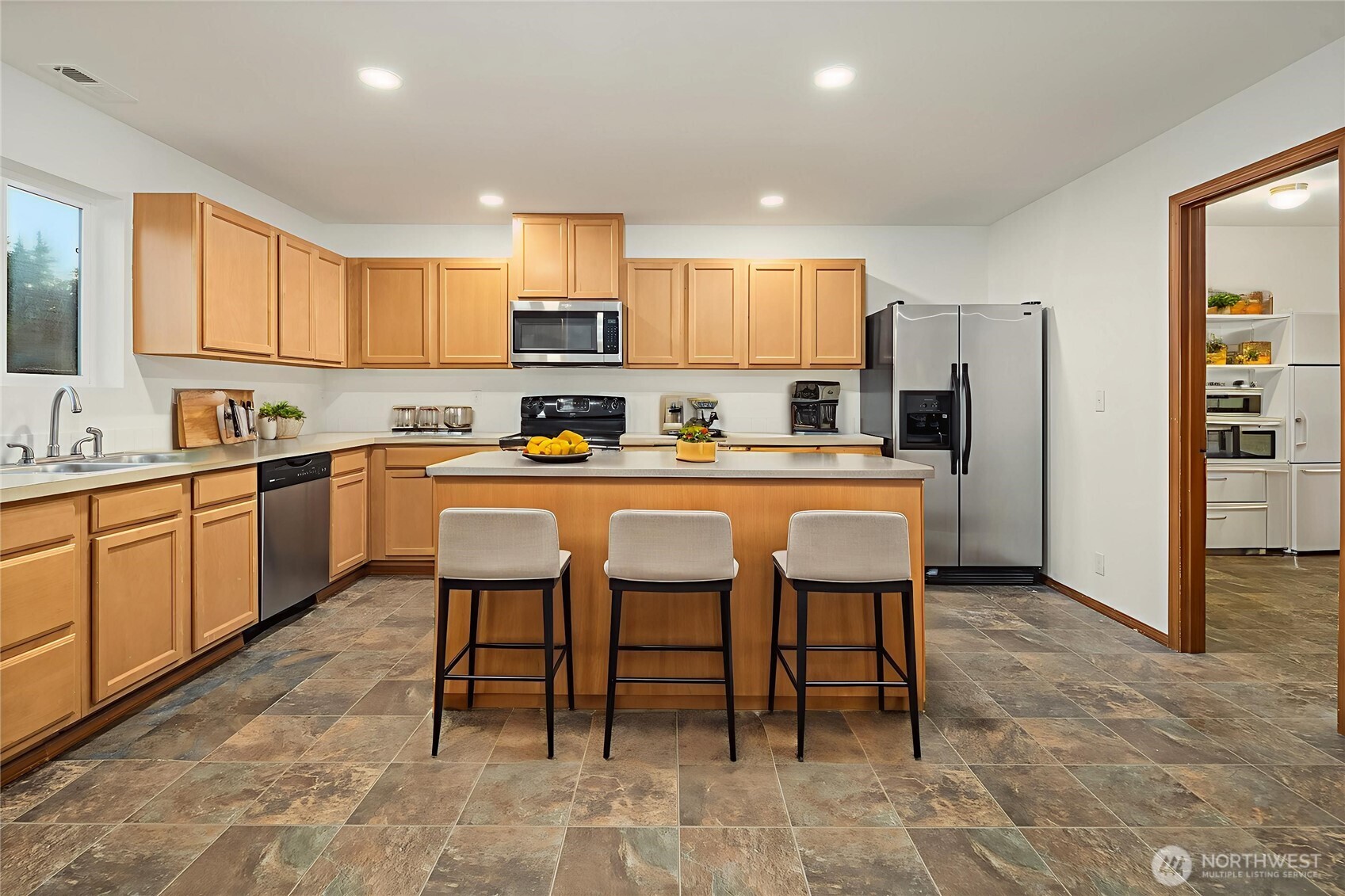 21353 Southeast 289th Way Kent, WA 98042 - Photo 4 of 40 a kitchen with stainless steel appliances kitchen island granite countertop a table chairs sink and cabinets