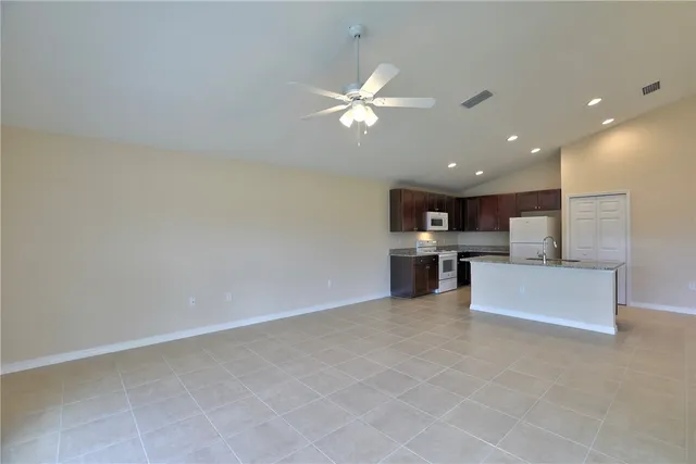 a view of kitchen with kitchen island sink and refrigerator