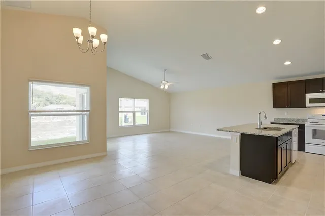 a kitchen with a sink a stove a refrigerator and cabinets