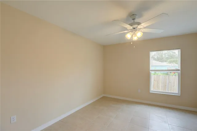 an empty room with a chandelier fan and fan