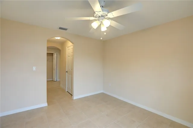 an empty room with chandelier fan