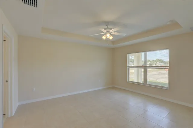 a view of an empty room with a chandelier fan