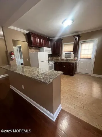 a large kitchen with granite countertop a stove and a refrigerator