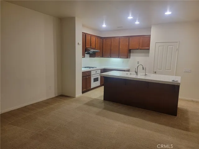 a kitchen with stainless steel appliances granite countertop a sink a stove a refrigerator and cabinets