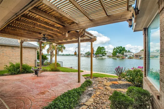 a view of a lake with a table and chairs under an umbrella