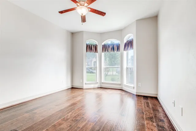 wooden floor in an empty room with a window