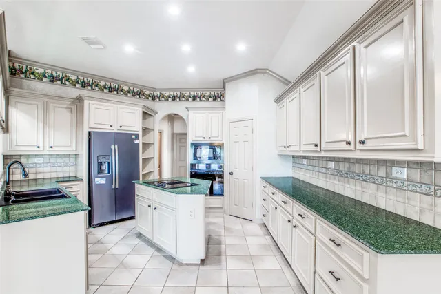 a kitchen with stainless steel appliances granite countertop a refrigerator and a sink