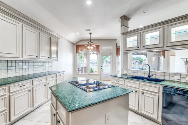 a kitchen with stainless steel appliances granite countertop a sink a stove and cabinets