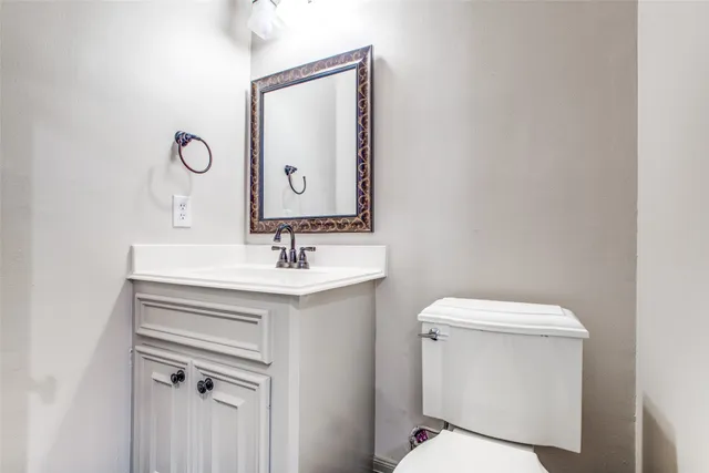 a bathroom with a sink mirror vanity and toilet