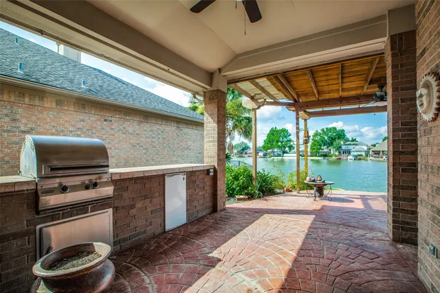 a view of a patio with a table chairs potted plants and a barbeque grill