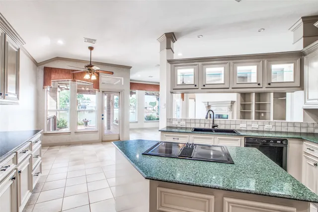 a large kitchen with granite countertop a lot of windows