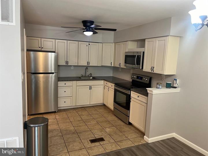 11 Kent Place Sewell, NJ 08080 - Photo 3 of 19 a kitchen with a sink a refrigerator and white cabinets