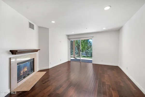 an empty room with wooden floor and a fireplace