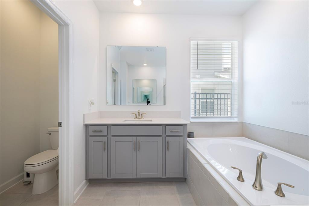 4507 Hillingdam Road Davenport, FL 33837 - Photo 45 of 83 a bathroom with a granite countertop sink a toilet and bathtub