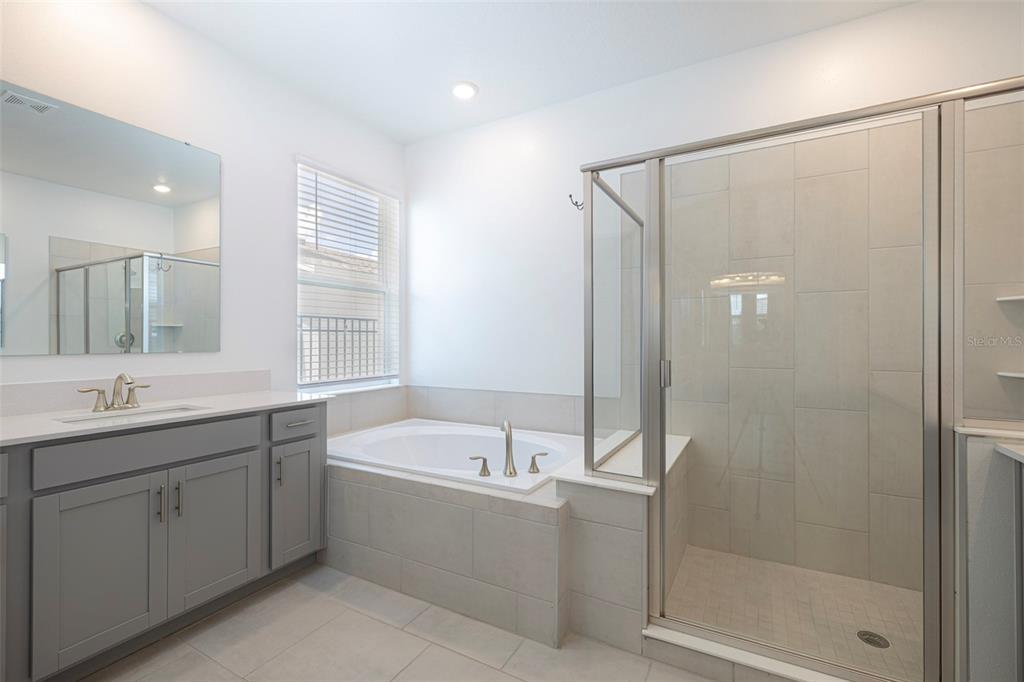 4507 Hillingdam Road Davenport, FL 33837 - Photo 46 of 83 a bathroom with a bathtub a sink a shower and a mirror