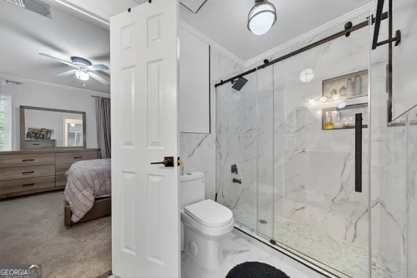 a bedroom with a bed a dresser and a large window