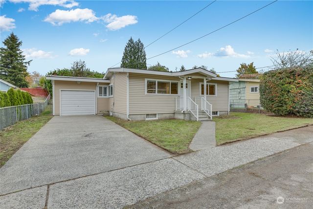 a front view of house with yard and trees around