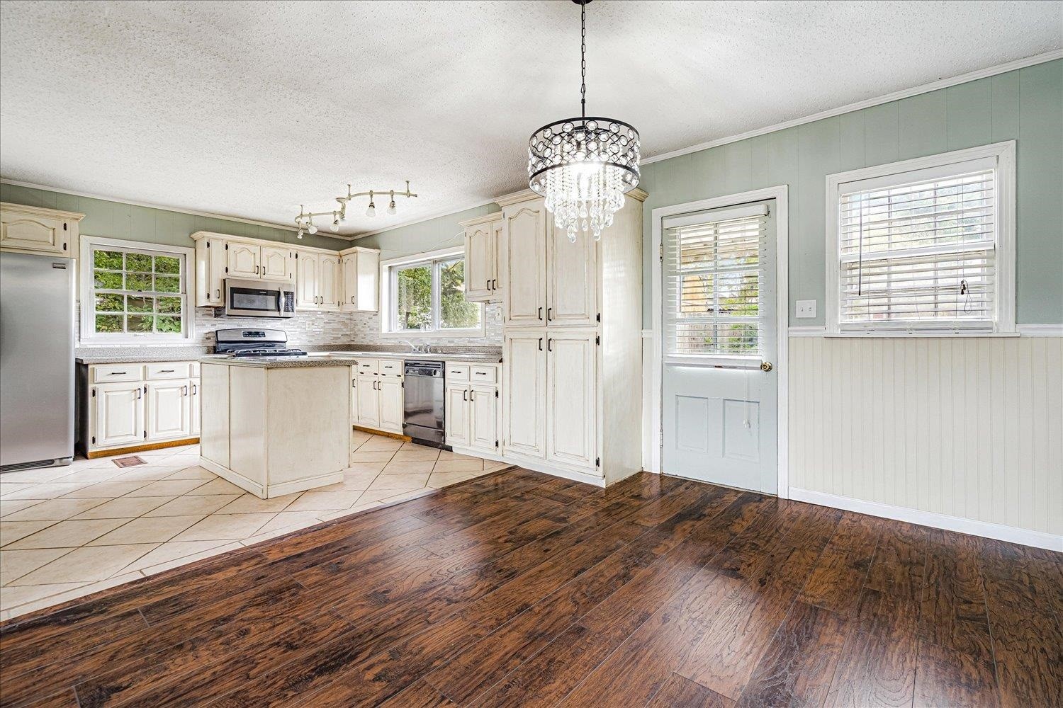 210 Kinney Avenue Covington, TN 38019 - Photo 12 of 28 a open kitchen with granite countertop a stove top oven a sink dishwasher a refrigerator and white cabinets with wooden floor