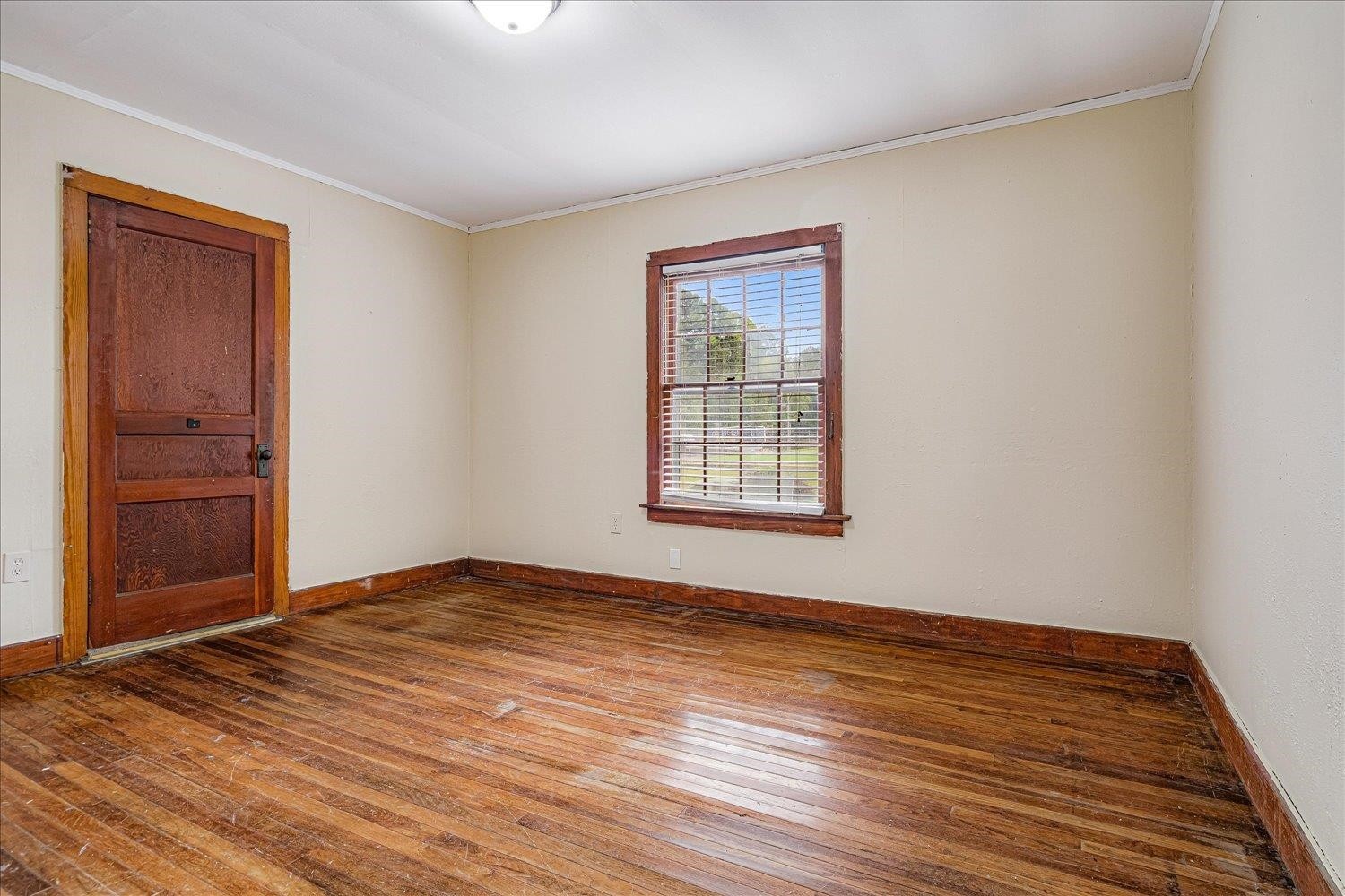210 Kinney Avenue Covington, TN 38019 - Photo 17 of 28 a view of an empty room with wooden floor and a window