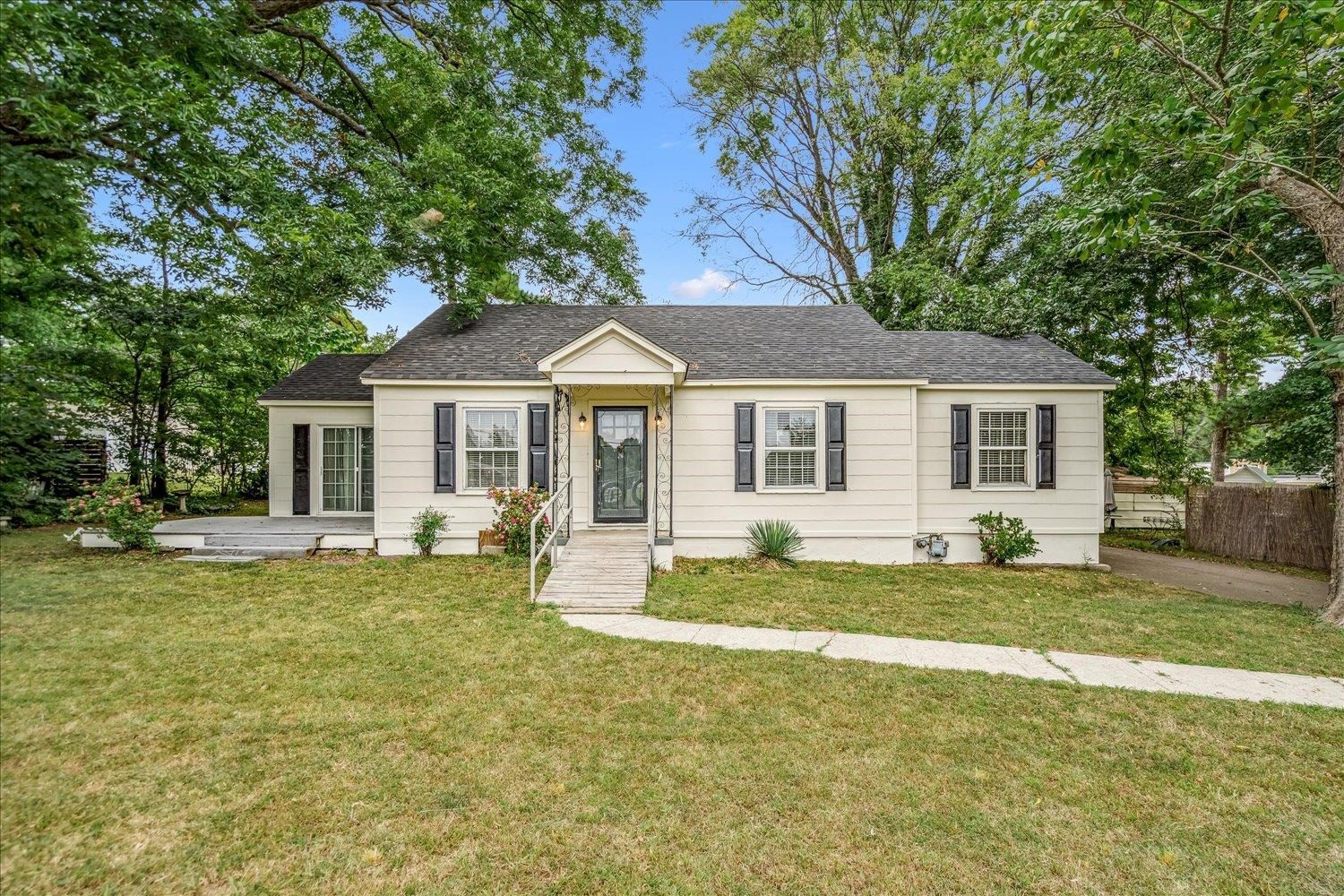 210 Kinney Avenue Covington, TN 38019 - Photo 3 of 28 a front view of a house with a garden and trees