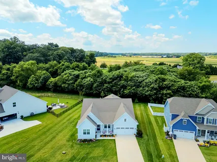 an aerial view of a house with pool big yard and large trees