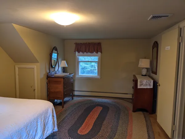 a bedroom with a bed and a dresser in it