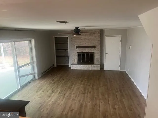 a view of an empty room with a fireplace and a window