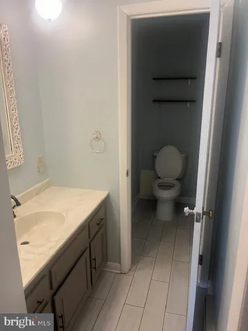 a bathroom with a granite countertop toilet and a sink