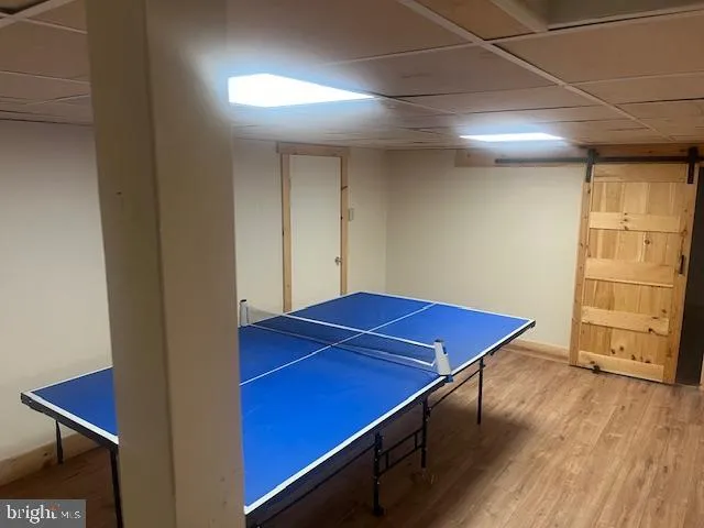a room with pool table and wooden floor
