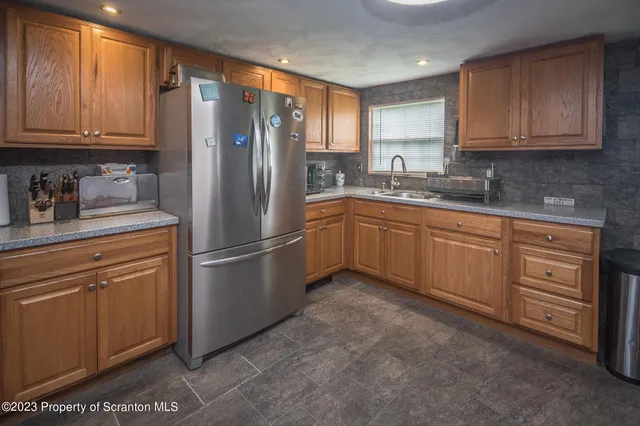 a kitchen with stainless steel appliances granite countertop a refrigerator sink and cabinets