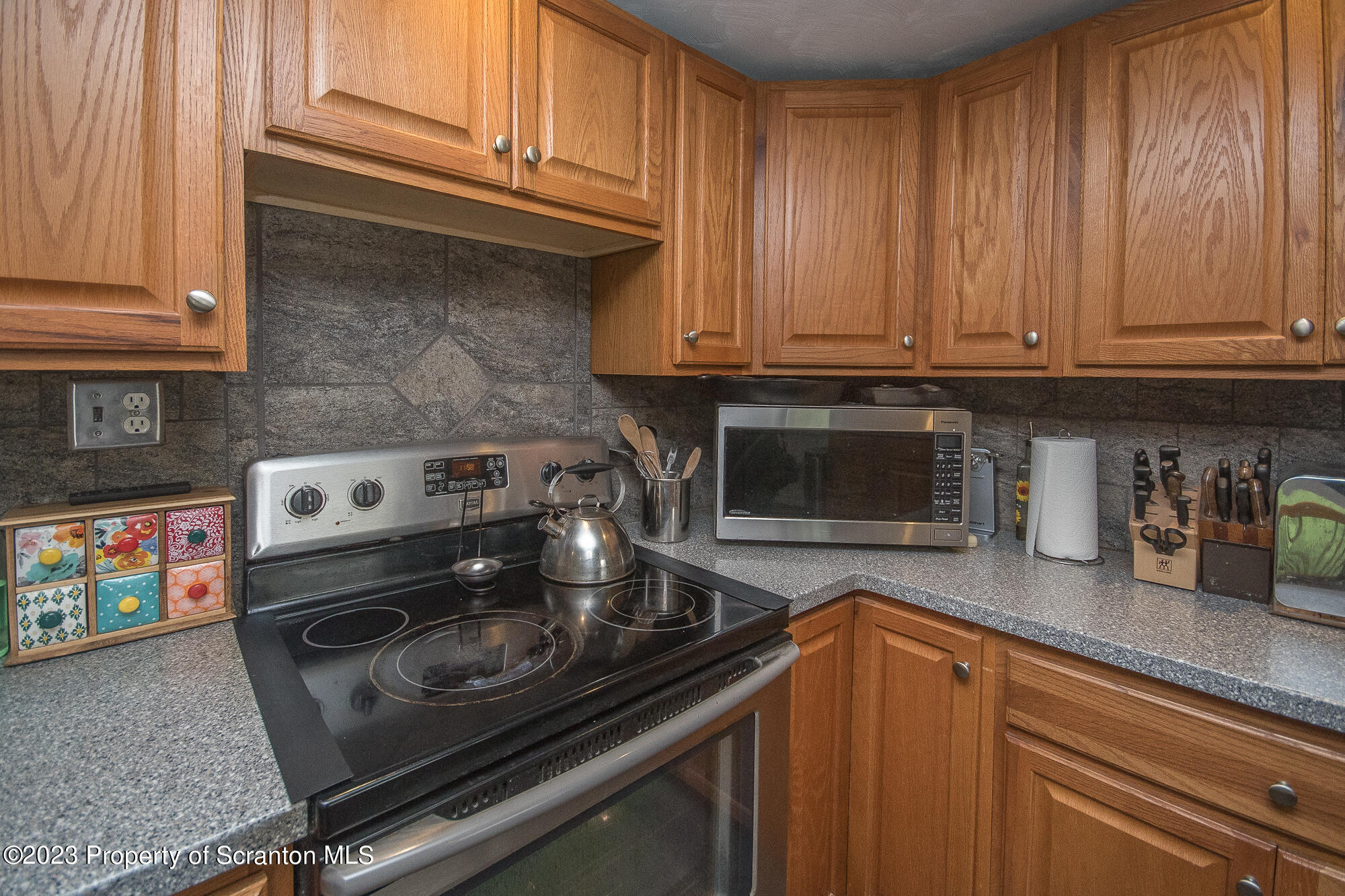 776 Milanville Road Beach Lake, PA 18405 - Photo 17 of 28 a kitchen with granite countertop a stove top oven and cabinets