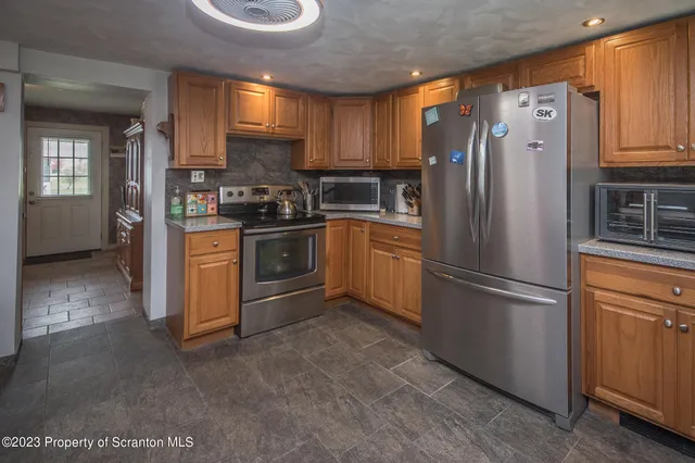 a kitchen with stainless steel appliances granite countertop a refrigerator sink and cabinets