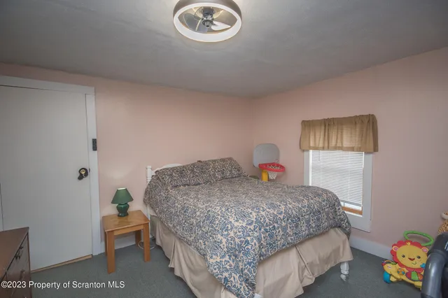 a bedroom with a bed and a lamp on dresser