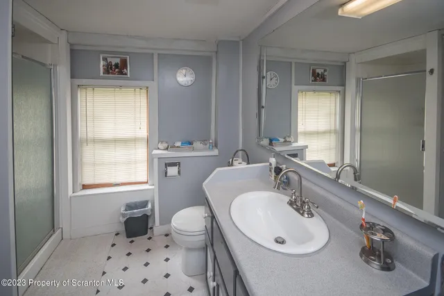 a bathroom with a sink toilet a mirror and shower