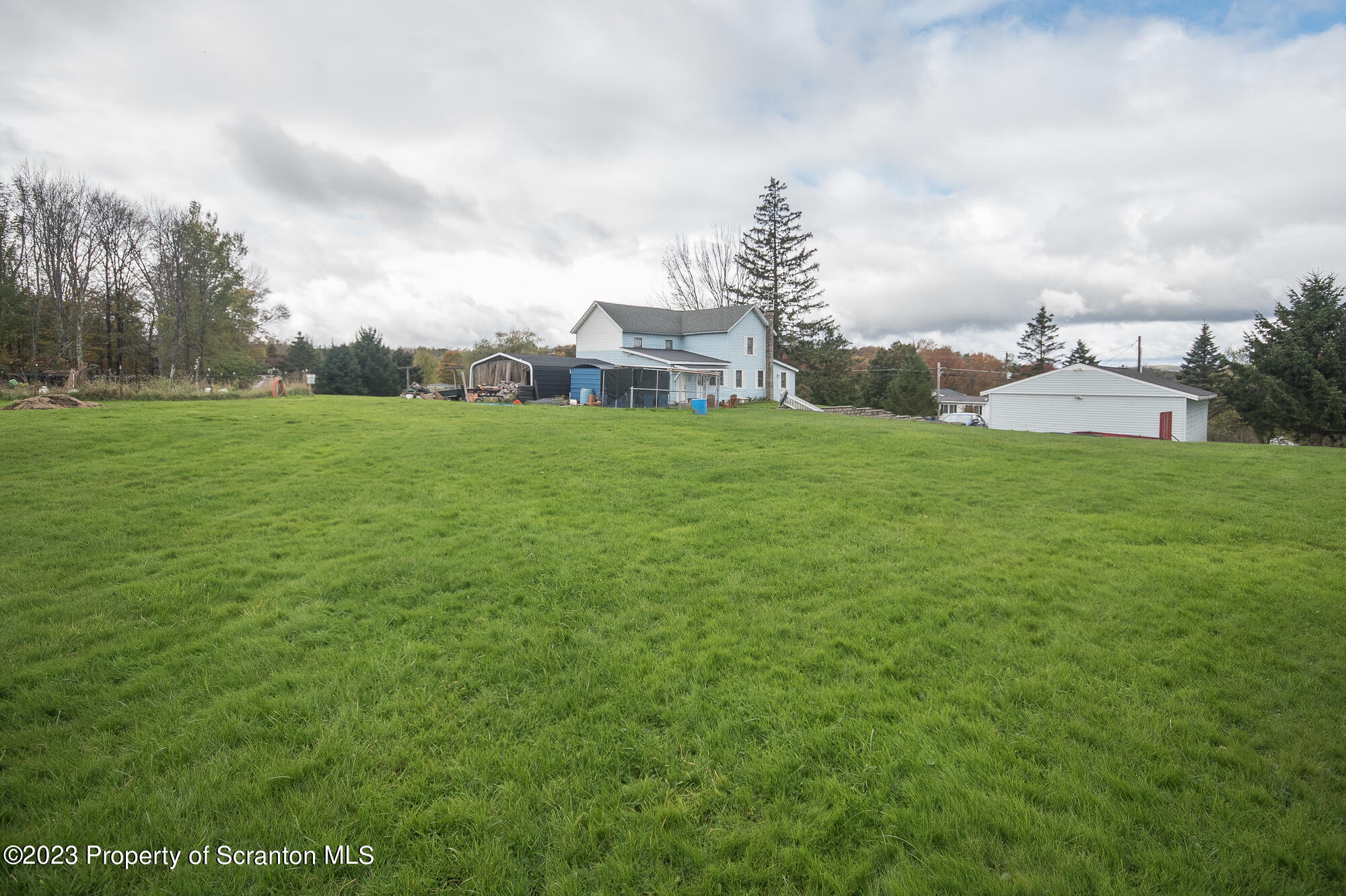 776 Milanville Road Beach Lake, PA 18405 - Photo 27 of 28 a view of a garden with a building in the background