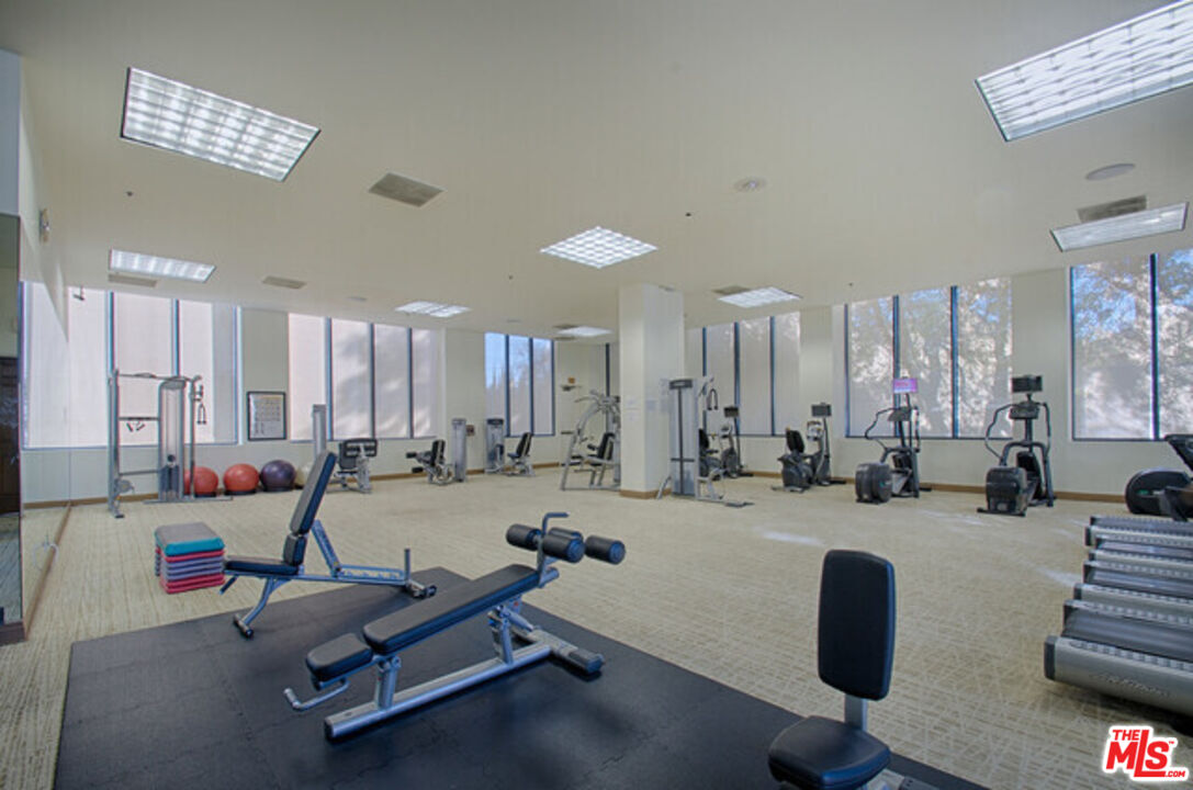 10724 Wilshire Boulevard, Unit 1001 Los Angeles, CA 90024 - Photo 14 of 20 a room with gym equipment and windows