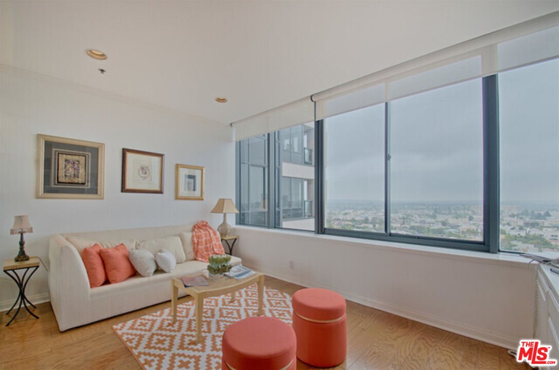 10724 Wilshire Boulevard, Unit 1001 Los Angeles, CA 90024 - Photo 7 of 20 a living room with furniture a table and a large window