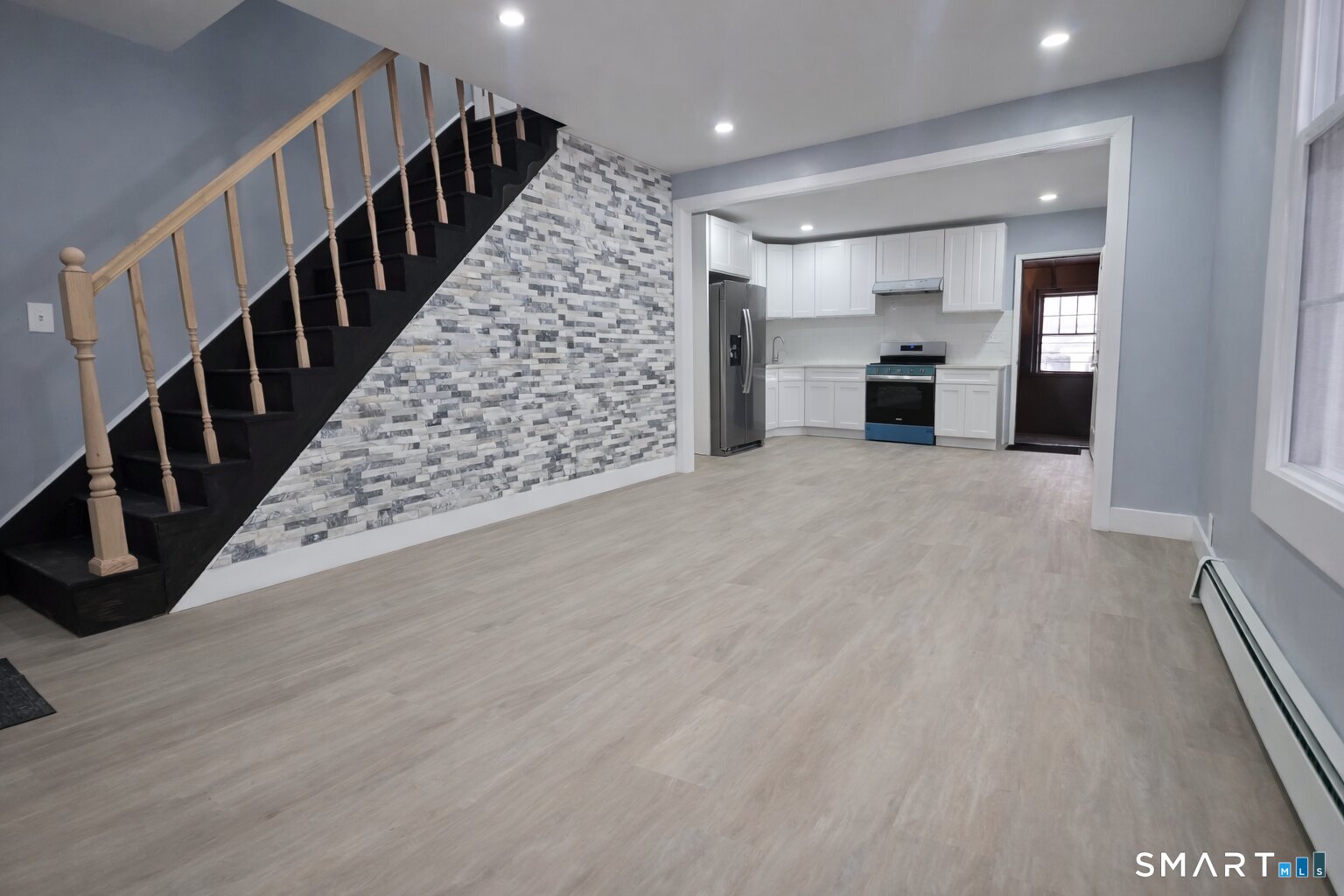 212 Platt Street Waterbury, CT 06704 - Photo 19 of 23 a view of an empty room with wooden floor and stairs