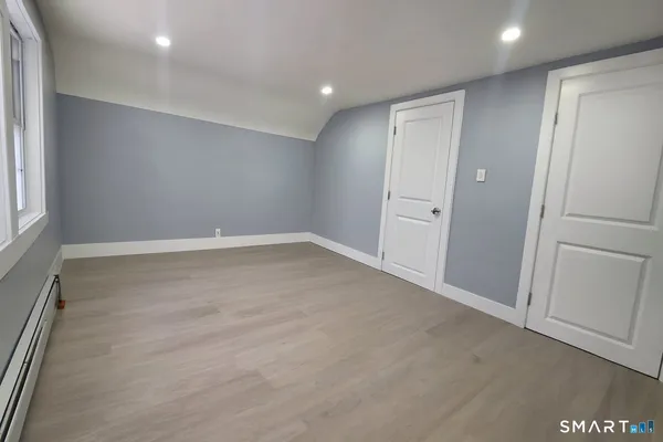 an empty room with wooden floor and window