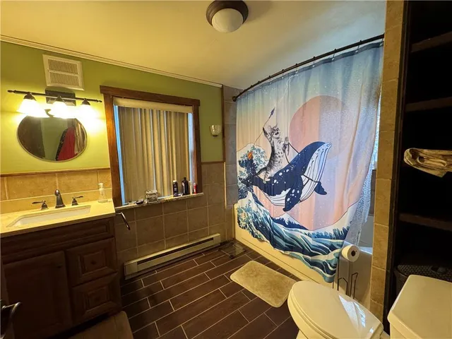 an empty room with wooden floor closet and windows