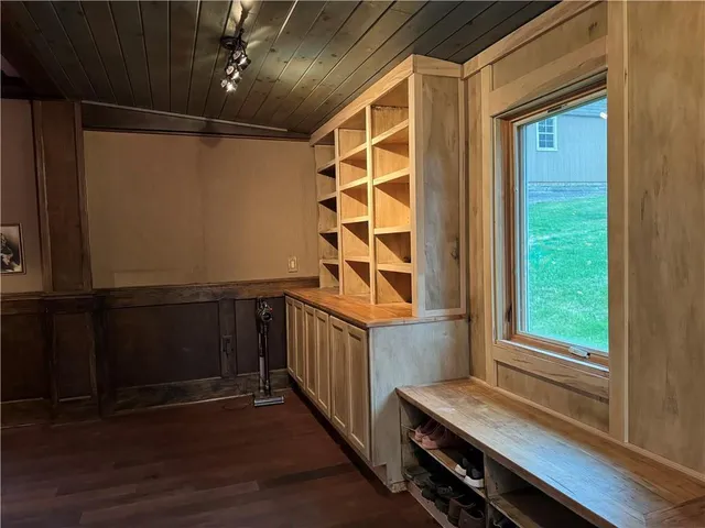 a view of an empty room with wooden floor and cabinets