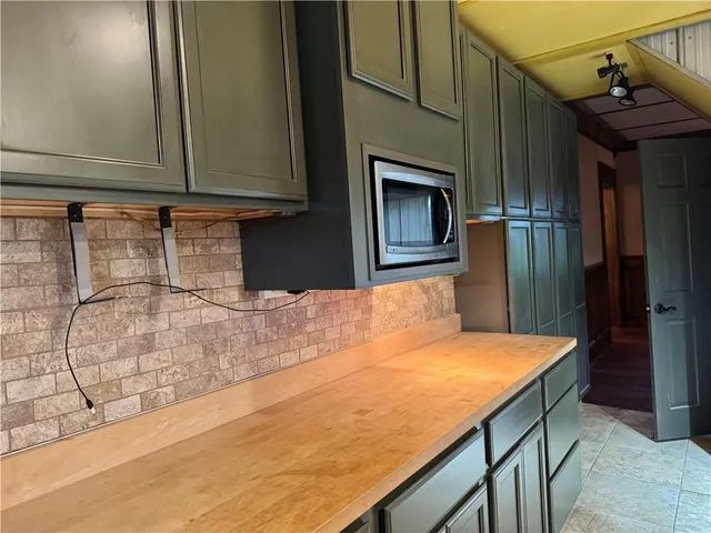 a kitchen with kitchen island a large counter top space appliances and a window