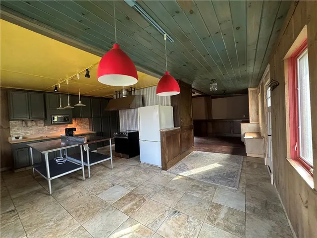 a view of a kitchen with refrigerator and a stove