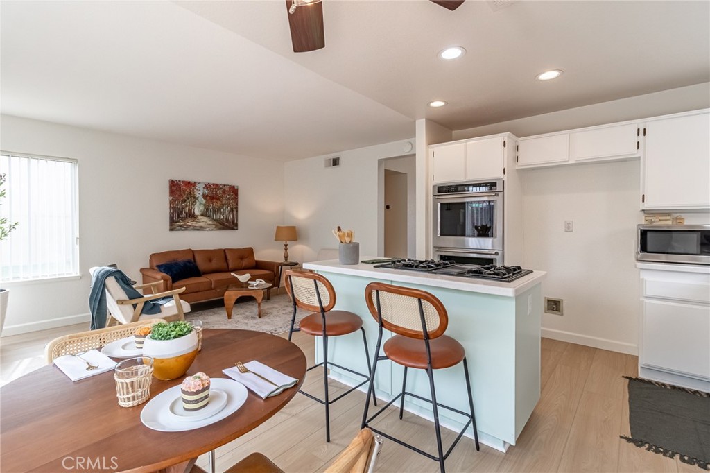 7529 Hardy Avenue Rancho Cucamonga, CA 91730 - Photo 14 of 38 a kitchen with stainless steel appliances granite countertop a sink a stove a microwave a dining table and chairs