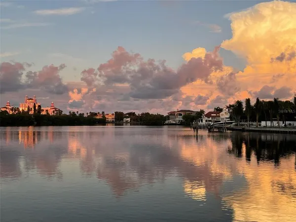 a view of a ocean with boats and trees in the background