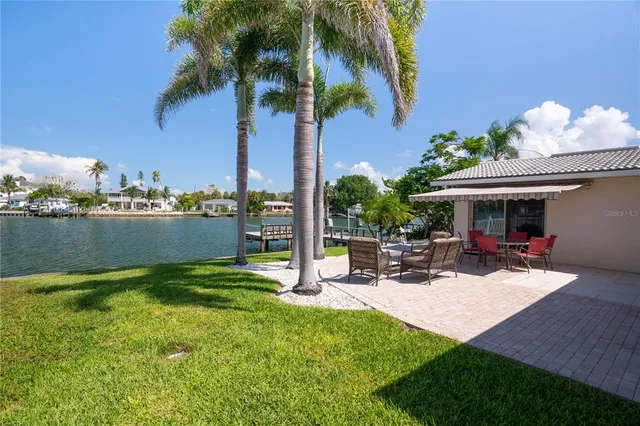 a large kitchen with a large counter space a sink appliances and cabinets
